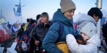 Молода дівчина з України чекає зі своєю матір'ю та собакою після перетину кордону з Польщею у 2022 році. Фото: PA